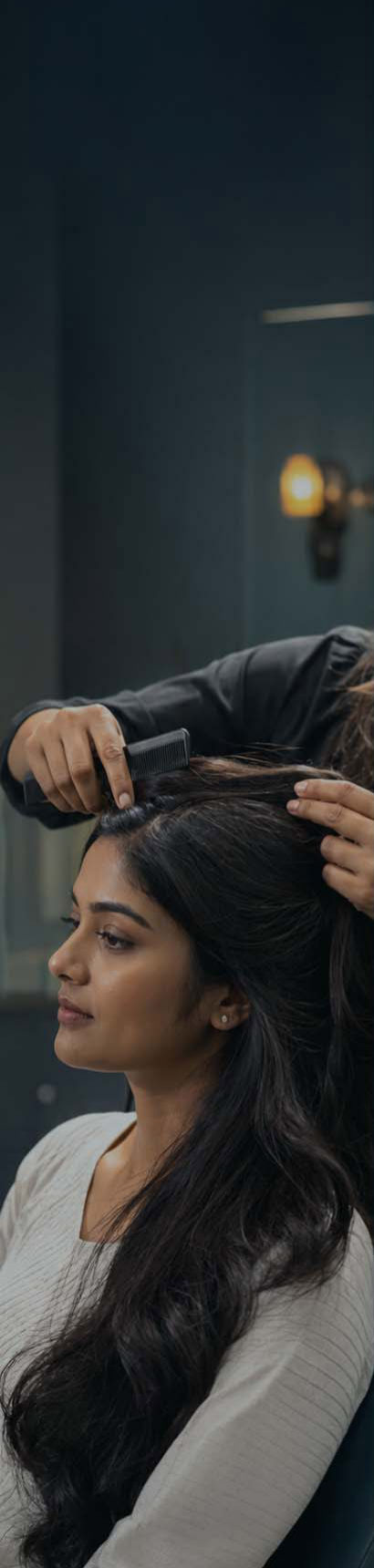 Stylist combing and sectioning a client's long dark hair